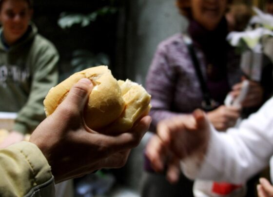 pessoa distribuindo um pedaço de pão