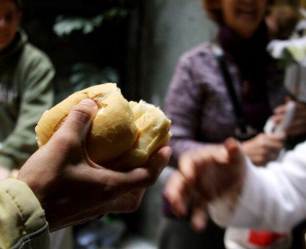 pessoa distribuindo um pedaço de pão